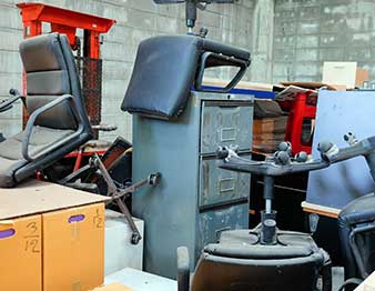 old office furniture piled in storage room