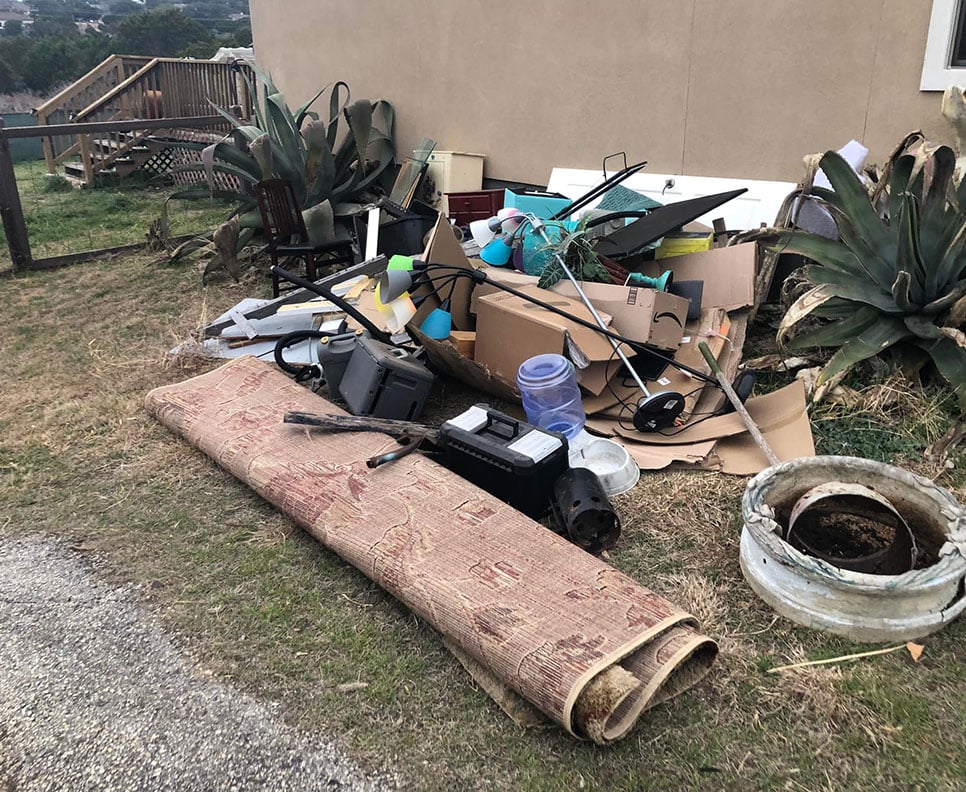 pile of bulk trash sitting outside of house