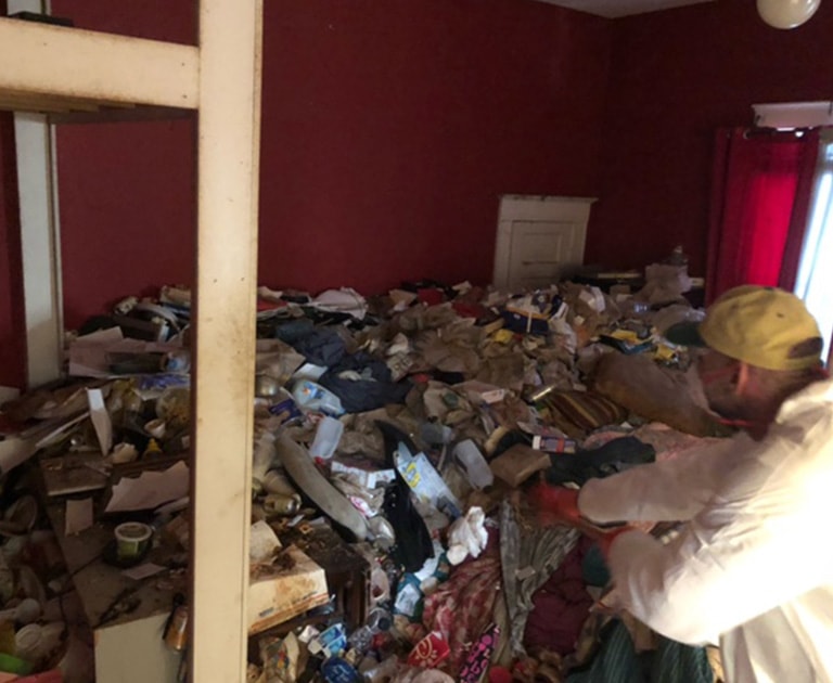 close-up of employee cleaning hoarder house before