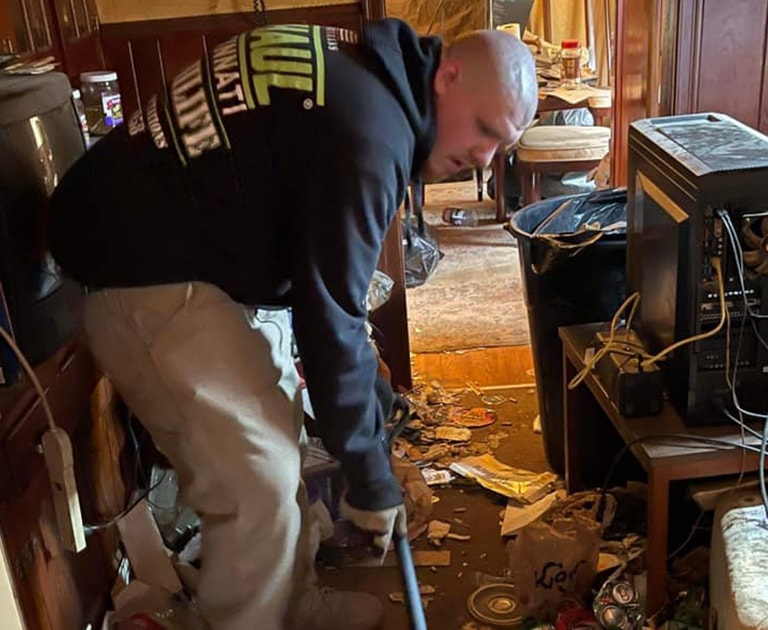 close-up of gentleman cleaning out hoarder house