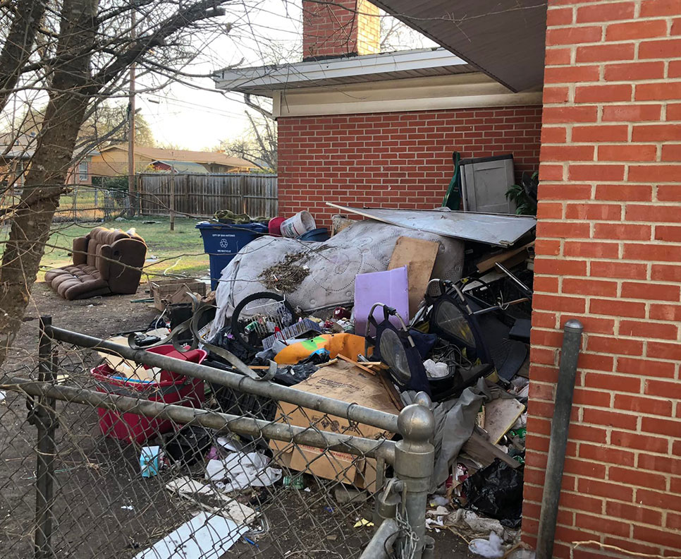 pile of garbage in the backyard of a house
