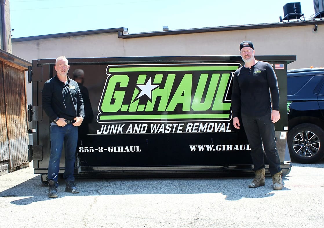 mike and dave smiling in front of ghaul dumpster
